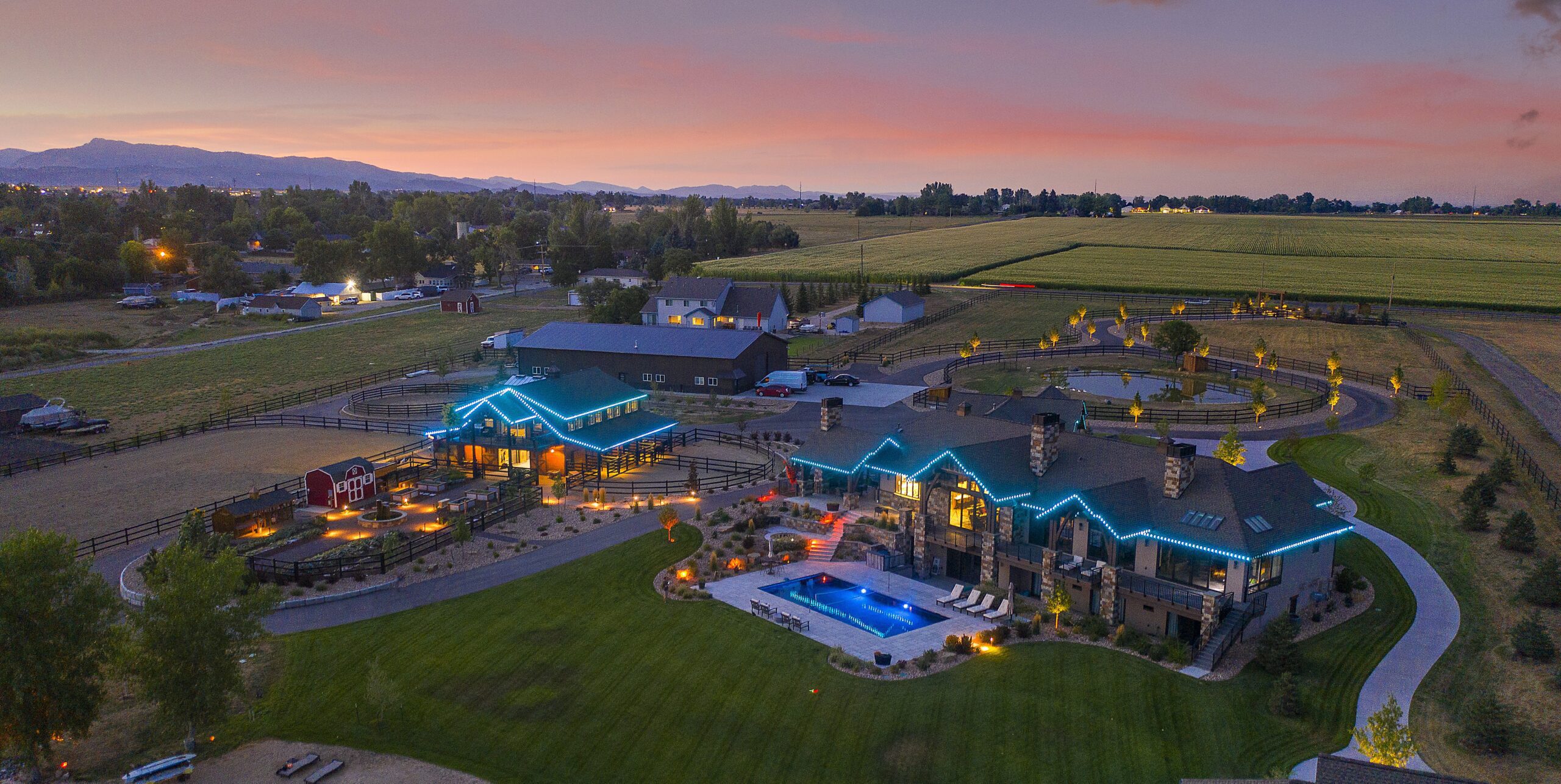 Aerial picture of bright green permanent decorative lighting on large home and barn