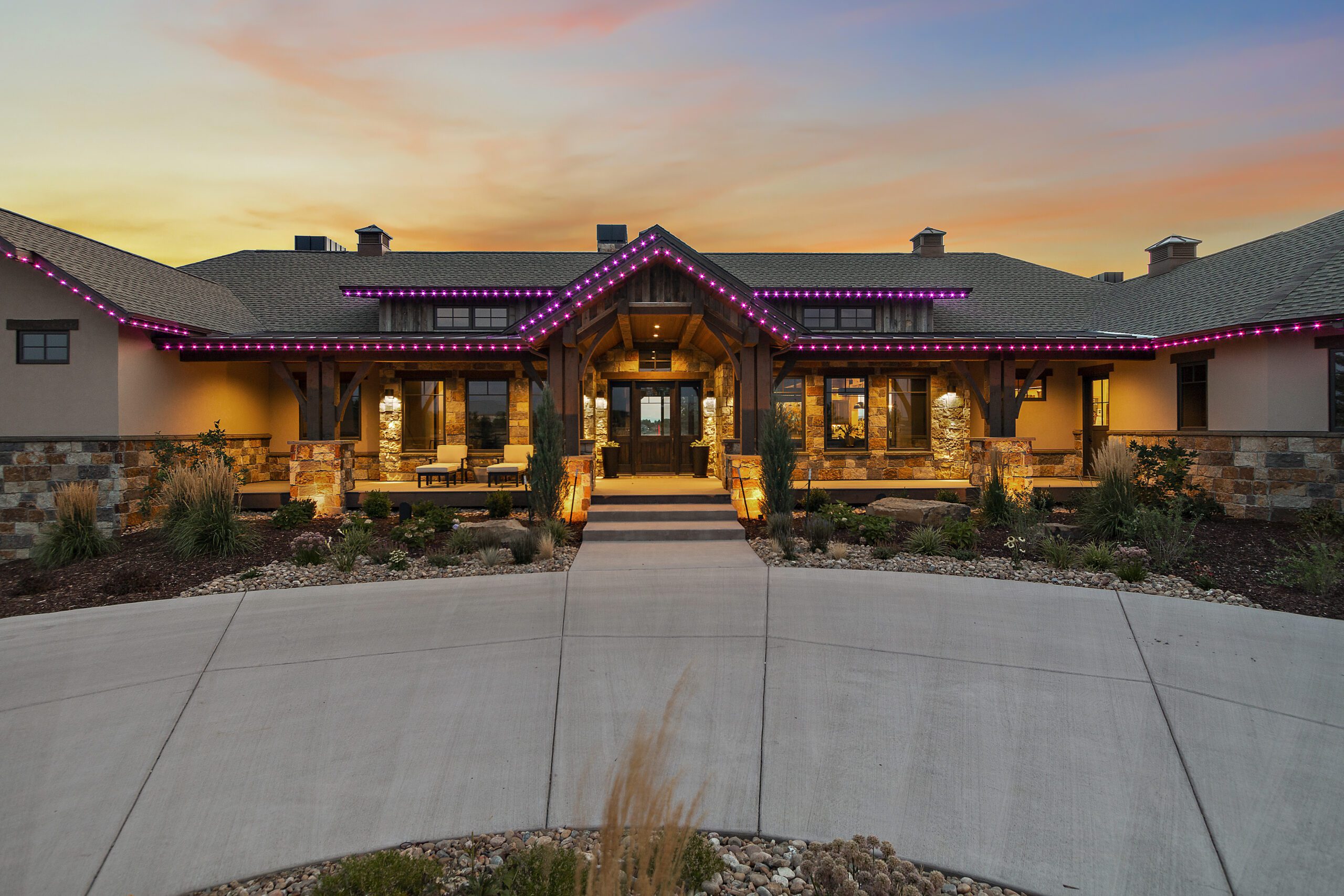 Pink LED lighting on roofline of single story brick home