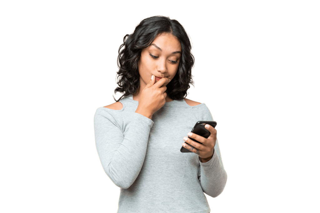 Female in grey sweater thinking while looking at her phone