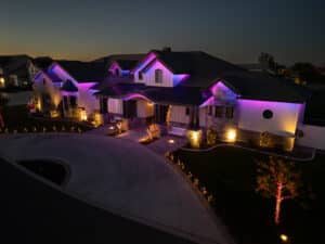 Home adorned with purple and blue permanent Christmas lights on the roofline.