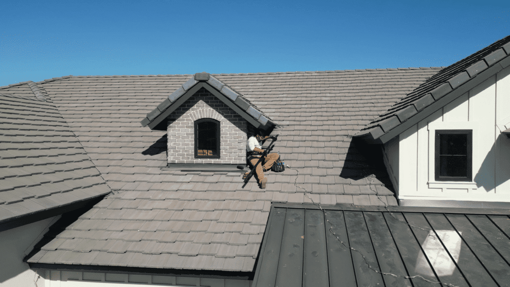 Man sitting on roof while putting LEDs into a trim light track