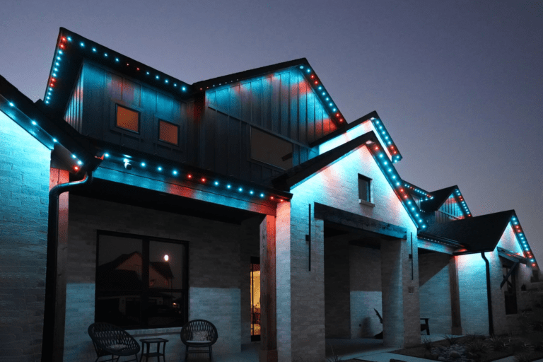 Permanent roofline lighting in red and blue showcasing festive designs on a modern home.