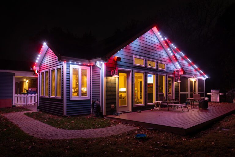 Permanent Christmas lights in a red and white theme illuminating a cozy home.