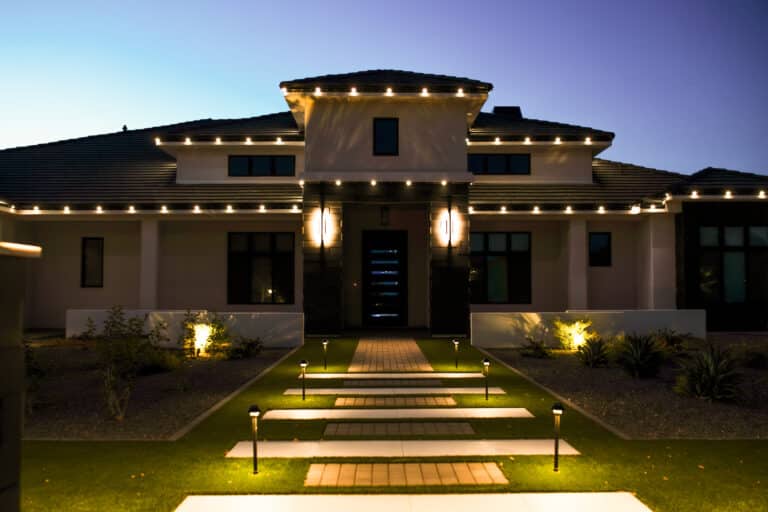 Modern Arizona home with warm white permanent LED trim lighting and illuminated front walkway at dusk