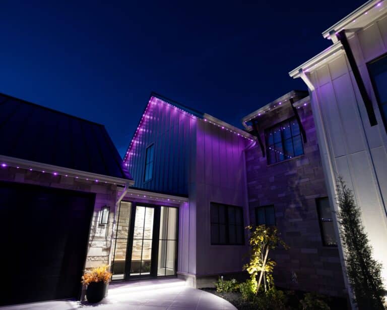 Modern luxury home illuminated with purple permanent architectural lighting at dusk